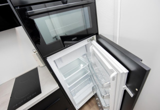 Forno a incasso e frigorifero aperto nella cucina della houseboat 'De Waterparel' in Friesland, Paesi Bassi.