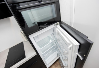 Horno empotrado y frigorífico abierto en la cocina del houseboat 'De Waterparel' en Friesland, Países Bajos.