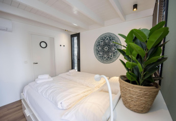 Dormitorio luminoso en la casa flotante 'De Waterparel' en Welcome In - Friesland, Países Bajos, decoración moderna.