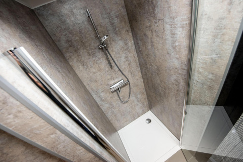 Moderna ducha con mampara de cristal y rociador en el houseboat 'De Waterparel' en Friesland, Países Bajos.