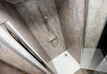 Modern shower with glass door and rain showerhead on houseboat 'De Waterparel' in Friesland, Netherlands.