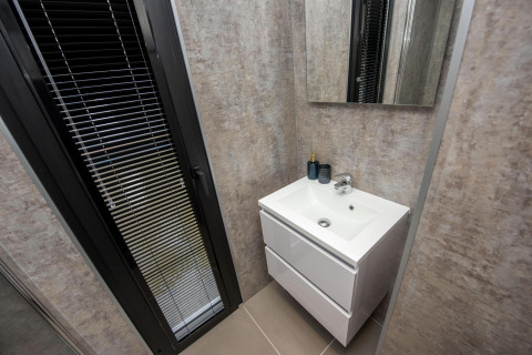 Baño moderno en la casa flotante 'De Waterparel' con lavabo y espejo, en Welcome In - Friesland, Países Bajos.