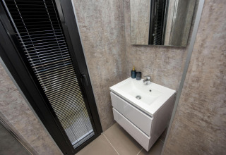Moderne badeværelse på husbåd 'De Waterparel' med vask og spejl, set på Welcome In - Friesland, Holland.