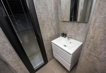 Baño moderno en la casa flotante 'De Waterparel' con lavabo y espejo, en Welcome In - Friesland, Países Bajos.