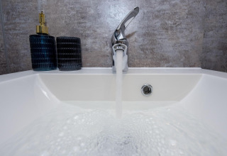 Faucet running into a sink inside Houseboat 'De Waterparel' at Welcome In - Friesland, Netherlands.