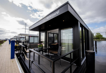 Modern houseboat 'De Waterparel' docked on the water at Welcome In - Friesland, Netherlands.