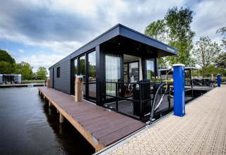Modernes Hausboot 'De Waterparel' bei Welcome In - Friesland, Niederlande, am Steg vor Anker liegend.