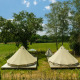 Dos tiendas tipi sobre plataformas de madera en un prado soleado en Holiday Park Mölke, Países Bajos.