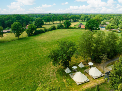 Vista aérea de tiendas tipi y sombrillas en un prado verde del Holiday Park Mölke en los Países Bajos.