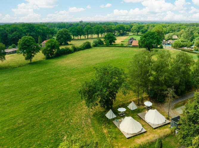 Aerial view of tipi tents and umbrellas on a green meadow at Holiday Park Mölke in the Netherlands.