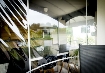 View through a window into the Tent Villa safari tent at Holiday Park Duinhoeve in the Netherlands with reflections.