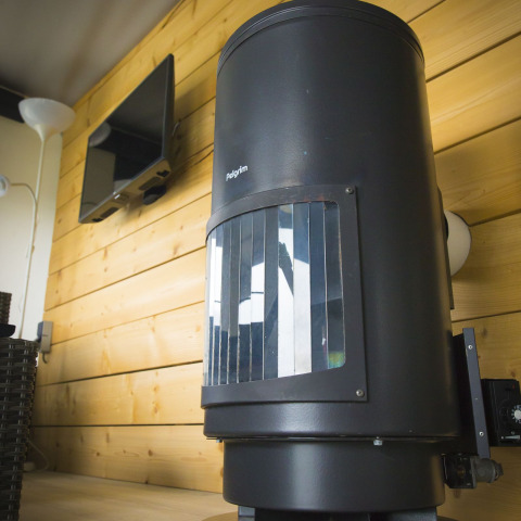 Zwarte houtkachel in Tent Villa, Holiday Park Duinhoeve, Nederland, tegen houten wand en tv.
