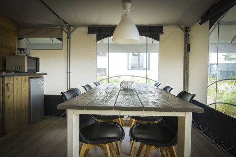 Área de comedor en la tienda safari Tent Villa en Holiday Park Duinhoeve, Países Bajos, con decoración moderna.
