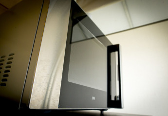 Close-up of a microwave oven inside the Tent Villa safari tent at Holiday Park Duinhoeve, Netherlands.