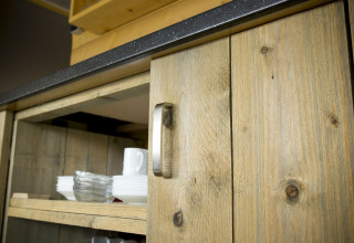 Primer plano de un armario de madera y encimera en la tienda Tent Villa en Holiday Park Duinhoeve, Países Bajos.