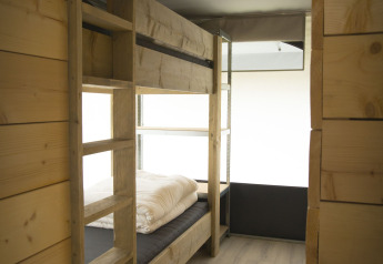 Interno della tenda safari Tent Villa all’Holiday Park Duinhoeve nei Paesi Bassi con letti a castello in legno.