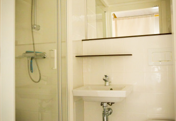 Baño en la tienda safari Tent Villa en Holiday Park Duinhoeve, Países Bajos, con ducha y lavabo modernos.