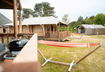 Safari tent Villatent Cottage with veranda, hammock, and grill at Vakantiepark De Nollen, Netherlands.