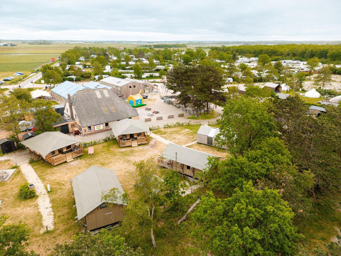 Luchtfoto van safaritenten en het hoofdgebouw bij Vakantiepark De Nollen, omringd door natuur in Nederland.