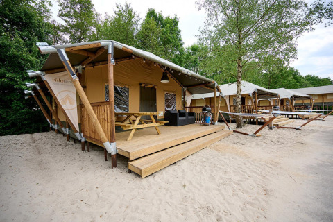 Safari tent Villatent Cottage at Vakantiepark Sallandshoeve in the Netherlands, with deck and sand.