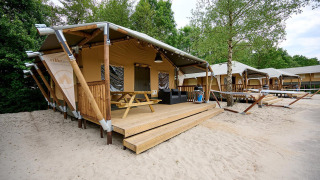 Safaritent Villatent Cottage bij Vakantiepark Sallandshoeve in Nederland, met houten terras.