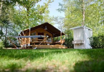 Safari telt Villatent Compact + med eget badeværelse og hængekøje i frodige omgivelser hos Recreatiepark de Lucht.