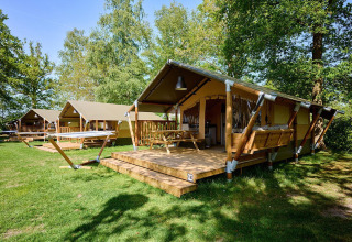 Safari-telt Villatent Compact + sanitær på Recreatiepark de Lucht i Holland, omgivet af grønne træer.