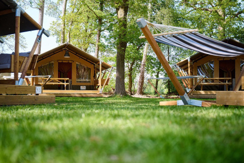 Safaritent Villatent Compact + sanitair bij Recreatiepark de Lucht in Nederland, omgeven door bomen.