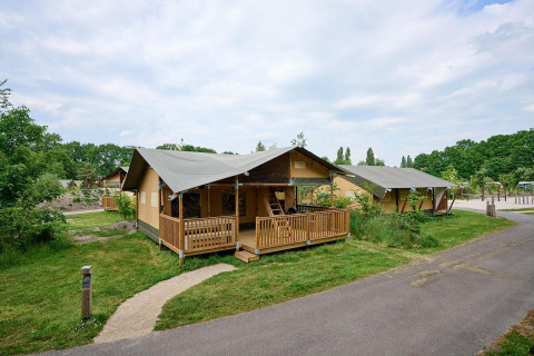 Safaritenten met houten veranda bij Villatent Ranger, Vakantiepark Sallandshoeve, Nederland, in het groen.