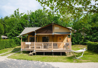 Tienda safari Villatent Ranger en Camping 't Geuldal, Países Bajos, con porche y hamaca en el jardín.