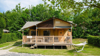 Tenda safari Villatent Ranger al Camping 't Geuldal nei Paesi Bassi, con veranda e amaca in giardino.