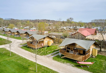 Buitenaanzicht van Villatent Ranger safaritenten op Camping 't Geuldal in Nederland, met veranda’s en hangmat.
