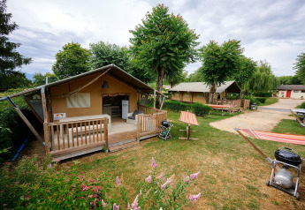 Tienda safari Villatent Nomad en Camping Le Coin Tranquille, Francia, con terraza y zona de barbacoa al aire libre.