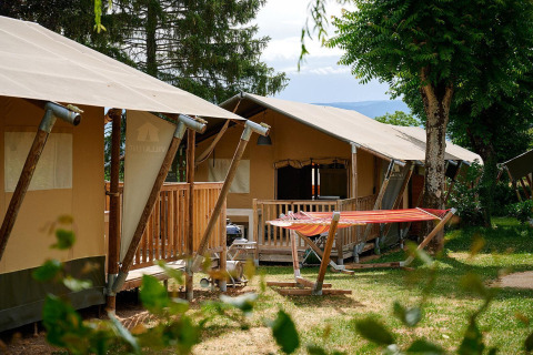 Safari tenten Villatent Nomad met veranda en hangmat op Camping Le Coin Tranquille in Frankrijk.
