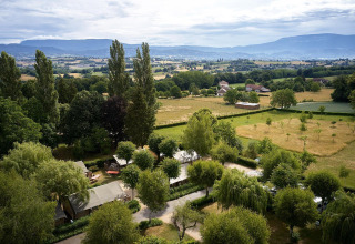 Vista aérea de la tienda safari Villatent Nomad en Camping Le Coin Tranquille, Francia, rodeada de naturaleza.