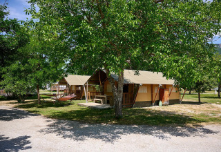 Tienda safari Villatent Nomad en Camping Le Lac Bleu, Francia, rodeada de árboles y naturaleza.