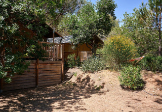 Tienda safari Villatent Nomad en Camping Leï Suves, Francia, rodeada de árboles y vegetación natural.