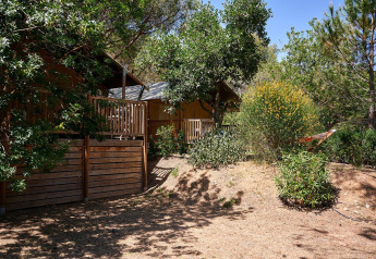 Tente safari Villatent Nomad au Camping Leï Suves en France, entourée d’arbres et de verdure naturelle.