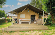 Tienda safari Villatent Nomad con terraza y zona de estar en Camping Les Genêts en Francia.