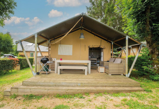 Safaritent Villatent Nomad op houten terras bij Camping Les Genêts met zitruimte in Frankrijk.