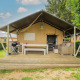 Tienda safari Villatent Nomad con terraza y zona de estar en Camping Les Genêts en Francia.