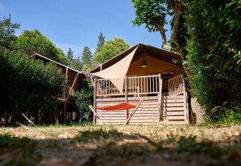 Tienda safari Villatent Nomad en Camping Les Pêcheurs, Francia, vista exterior con hamaca en primer plano.