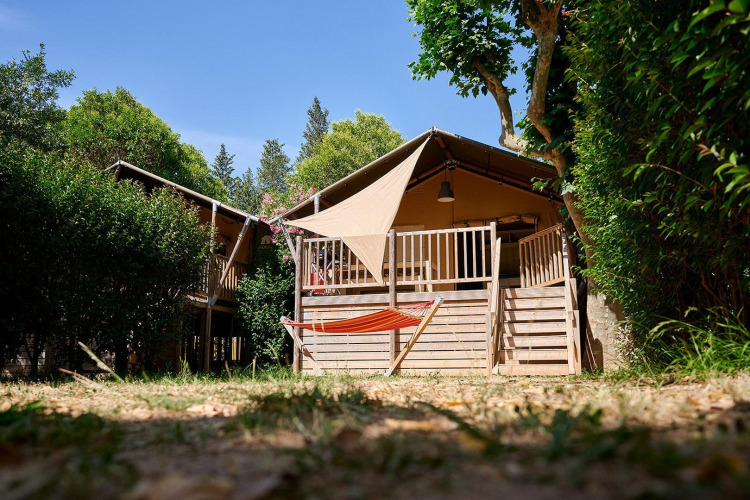 Safari-Zelt Villatent Nomad auf Camping Les Pêcheurs in Frankreich, mit Hängematte im Vordergrund.