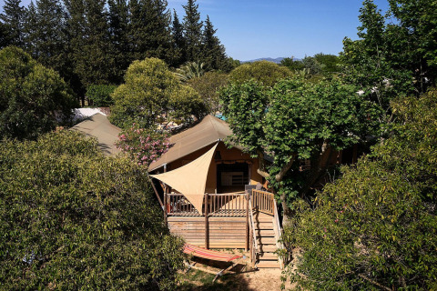 Tenda safari Villatent Nomad immersa nel verde al Camping Les Pêcheurs in Francia.