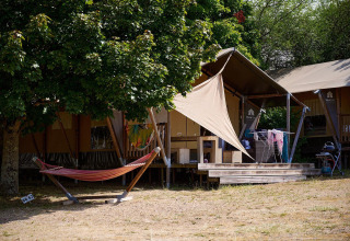 Safari-teltet Villatent Nomad på Camping Le Petit Trianon i Frankrig med hængekøje og udendørs terrasse.