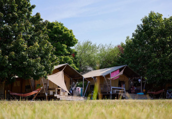Safari-Zelte Villatent Nomad auf dem Campingplatz Le Petit Trianon in Frankreich, umgeben von Bäumen.