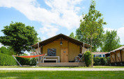Tienda safari Villatent Nomad en Camping 't Geuldal, Países Bajos, con hamaca y terraza de madera.