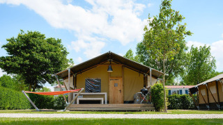 Safaritent Villatent Nomad op Camping 't Geuldal in Nederland met hangmat en houten veranda.