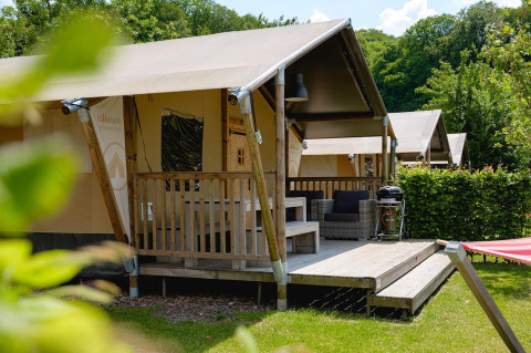 Safari tent Villatent Nomad met terras en zithoek op Camping 't Geuldal in Nederland.
