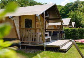 Tienda safari Villatent Nomad con porche y zona de estar en Camping 't Geuldal, Países Bajos.